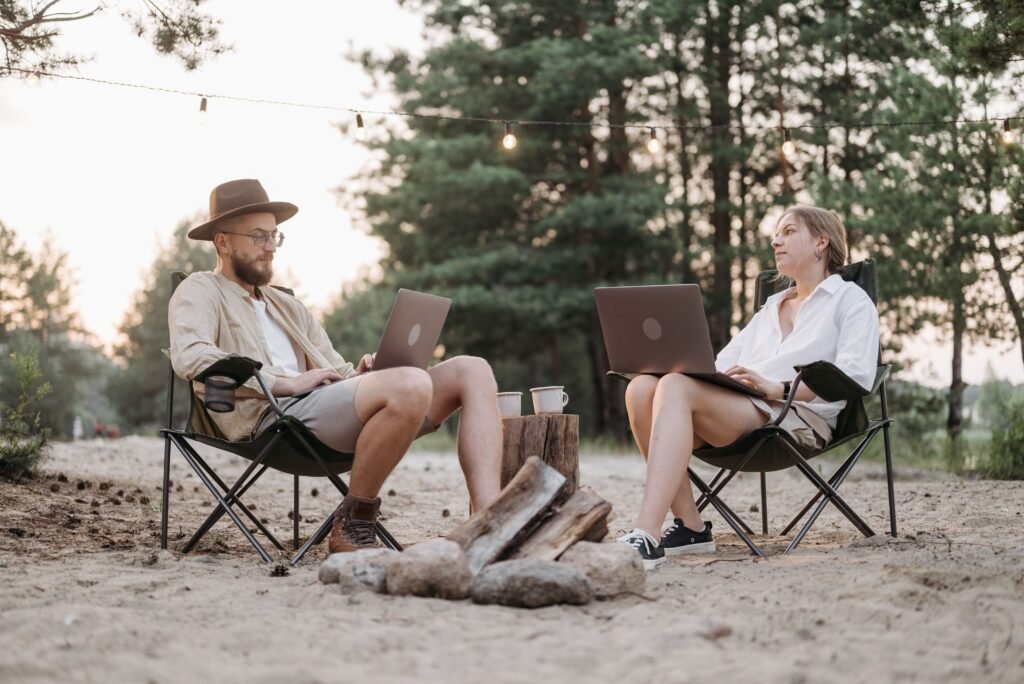 Digital nomads working remotely with laptops outdoors representing flexible international travel insurance coverage