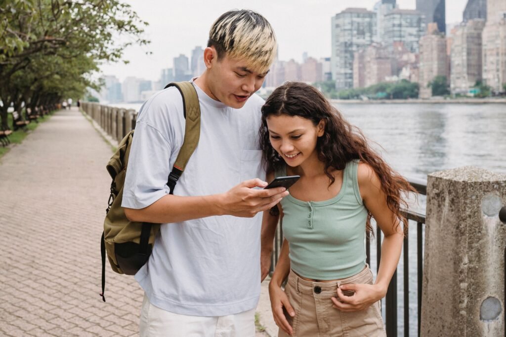 New York Passes vs Individual Tickets: tourists comparing a digital sightseeing pass on a smartphone