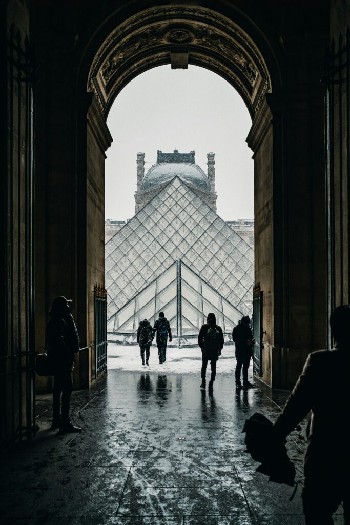 A traveler checking skip-the-line louvre tickets on a smartphone at the priority entrance lane