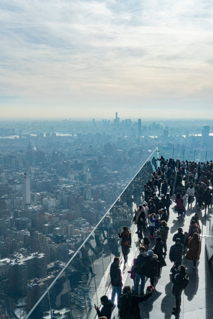 Tourists enjoying the Top of the Rock observation deck view over Manhattan.